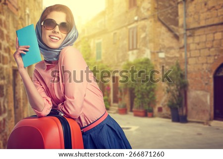Elegant woman with a suitcase travel and ticket on street of italian city Royalty-Free Stock Photo #266871260
