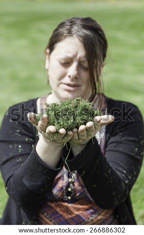Young woman blowing grass, detail of young girl in nature, freedom