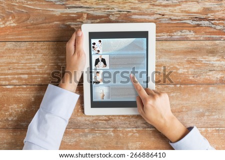 business, education, people, internet and technology concept - close up of male hands pointing finger to webpage article on tablet pc computer screen and coffee cup at table