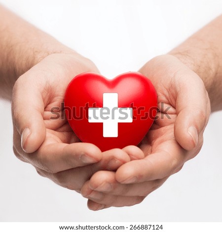 family health, charity and medicine concept - male hands holding red heart with cross sign