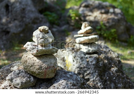 Stack of pebble stones by a stream in a forest 