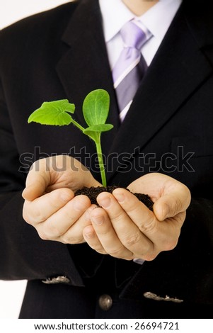 Picture about a businessman who keep in his hands a green sprout