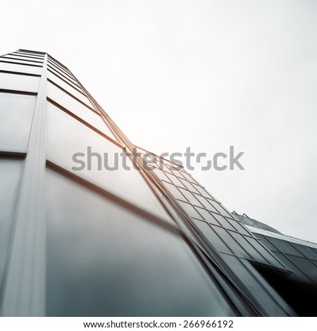 Wide angle abstract background view of steel light blue high rise commercial building skyscraper made of glass exterior. concept of successful industrial architecture and office center building