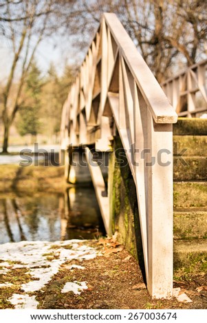 Crossing the bridge. Wooden bridge over a pond in the park.