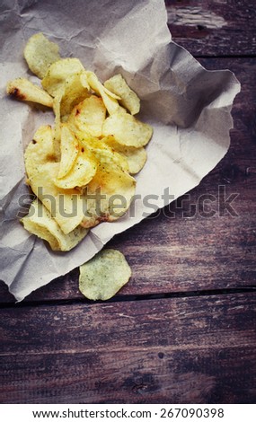 Potato chips over old wooden table. 