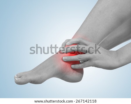 A young woman massaging her painful ankle. Medicine concept photo.