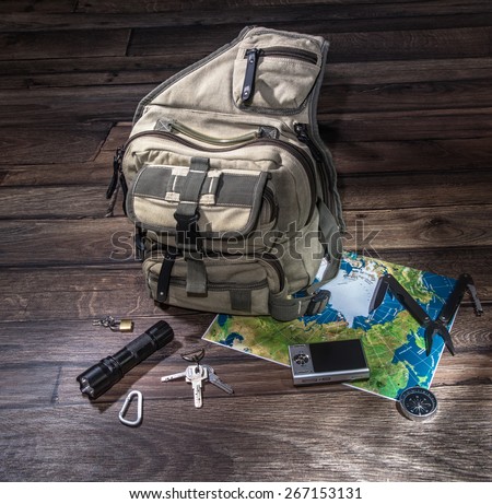 Backpack or rucksack with accessories for adventure. Survival equipment. 
Hiking gear laid out for a backpacking trip