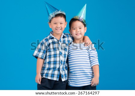 Portrait of two hugging friends in party hats
