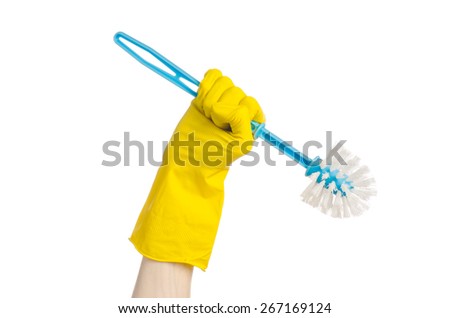 Cleaning the house and cleaning the toilet: human hand holding a blue toilet brush in yellow protective gloves isolated on a white background in studio