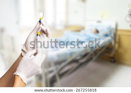  nurse fills a syringe medication from a vial with patient background