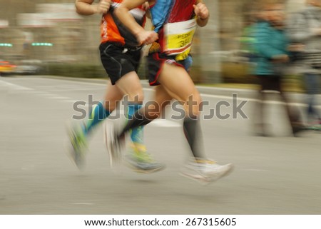 Runners legs on the road with panning blur Royalty-Free Stock Photo #267315605