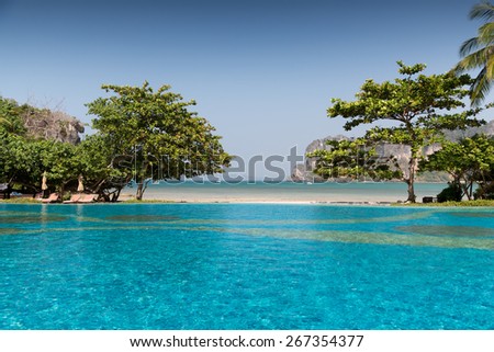 summer holidays, tourism, travel and leisure concept - swimming pool at thailand touristic resort beach Royalty-Free Stock Photo #267354377