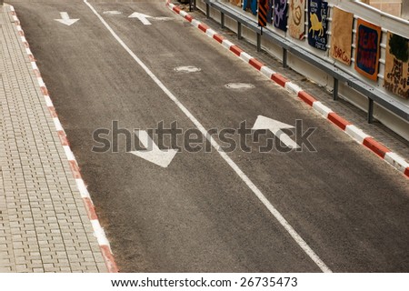 Close-up of a road with white line and arrows