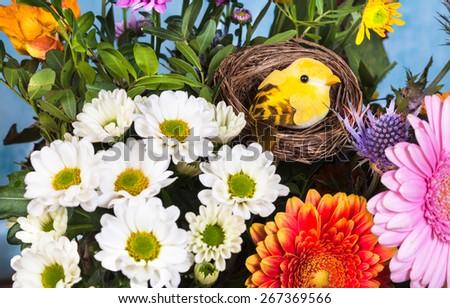 Little yellow bird in a bouquet of spring flowers, selective focus