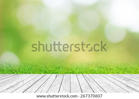 blur nature background with glow sunshine light and modern wood table top shelf perspective view for promote product concept.