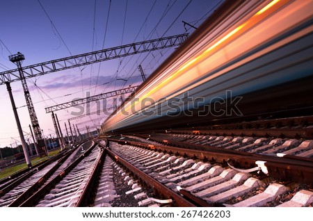 High speed passenger train on tracks with motion blur effect at sunset. Railway station in Ukraine Royalty-Free Stock Photo #267426203
