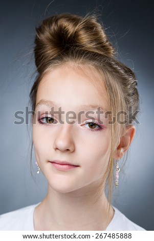 Portrait of a beautiful girl on a gray background in studio.