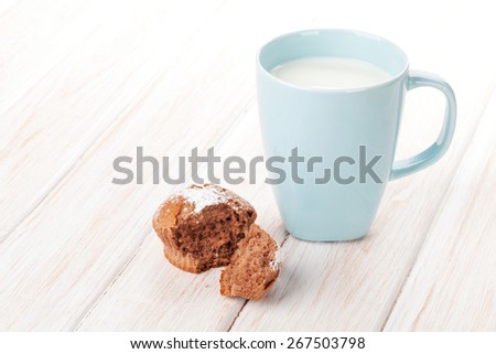 Cup of milk and cake on white wooden table