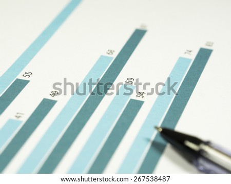 Business graphs and charts on the paper.
