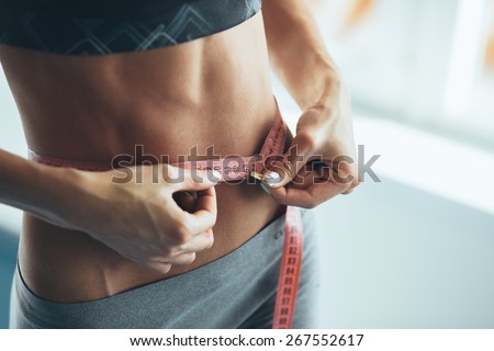 Woman losing weight Royalty-Free Stock Photo #267552617
