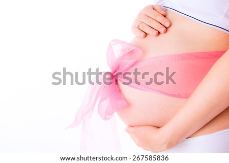 belly of a pregnant woman in a pink bow isolated on white, arms around the belly