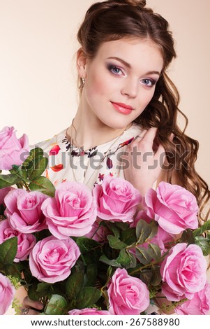 Pretty young girl is holding pink roses 