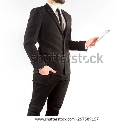 Hipster man in a classic suit isolated on a white background with a tablet in hand. High resolution. 