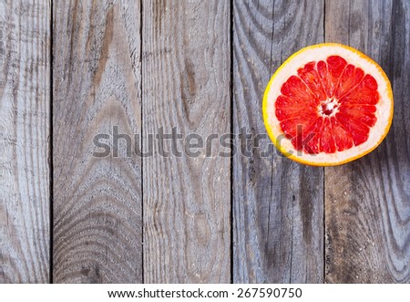 Half of a grapefruit on a wooden board.