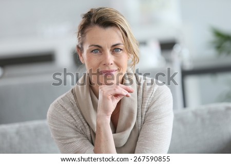 Portrait of smiling mature woman with hand on chin Royalty-Free Stock Photo #267590855