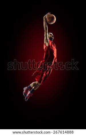 Isolated on black basketball player in action is flying high 