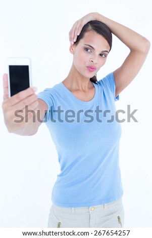 Beautiful brunette taking a selfie on white background