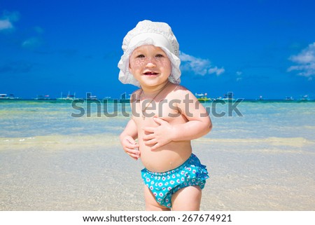 A little kid having fun on a tropical beach.