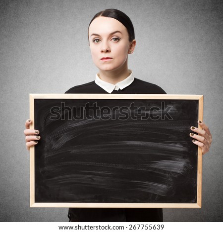 Retro portrait of a strict young woman holding a blackboard