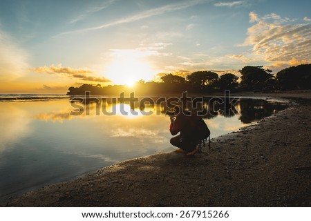 Man in travel make photo of the beautiful morning ocean at the sunrise.
