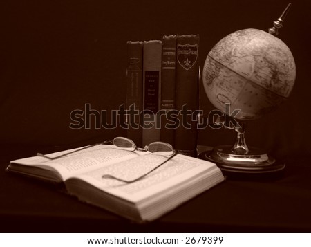 Photo of books with magnifying glass.
