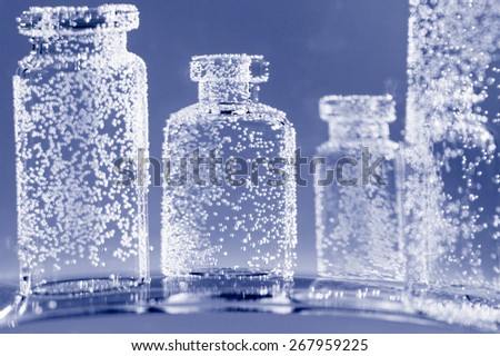 Abstract, underwater composition with small glass bottles and bubbles