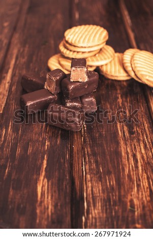 chocolate candies and cookies on a wooden brown background 