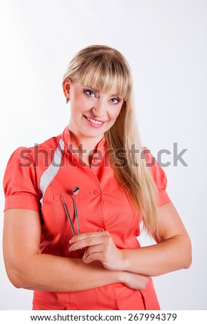 picture of attractive female dentist with tools on a white background