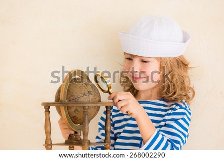 Happy child playing with vintage nautical things. Kid having fun at home. Summer sea dream and imagination. Adventure and travel concept