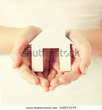 closeup picture of woman hands holding paper house