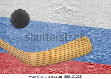 Hockey puck, hockey stick and the image of the Russian flag on the ice