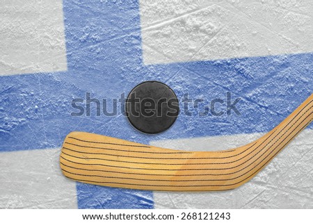 Hockey puck, hockey stick and the image of the Finnish flag on the ice