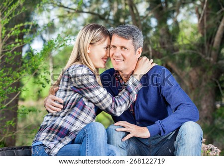 Portrait of happy man embracing girlfriend at campsite