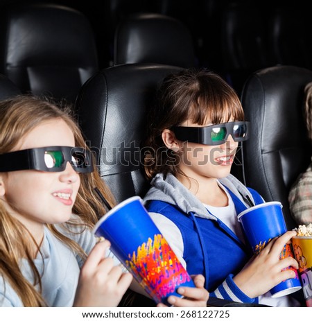 Children having snacks while watching 3D movie in cinema theater