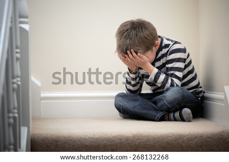 Upset problem child with head in hands sitting on staircase concept for bullying, depression stress or frustration Royalty-Free Stock Photo #268132268