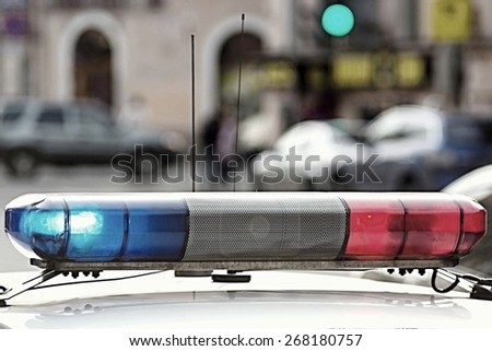 the police car provides control of a situation and patrol, the photo with a retro effect on indistinct a background of city streets and the motor transport
