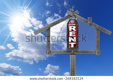 House For Rent Sign - Metallic Meter. Grey metallic meter ruler in the shape of house and label with text for rent. For rent real estate sign on blue sky with clouds and sun rays