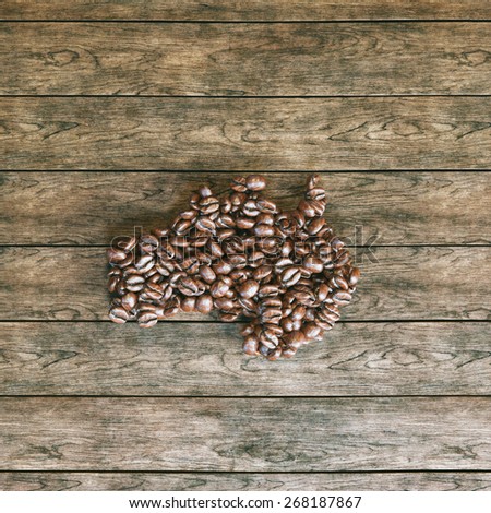 Map of Australia made of roasted coffee beans on vintage wooden background 