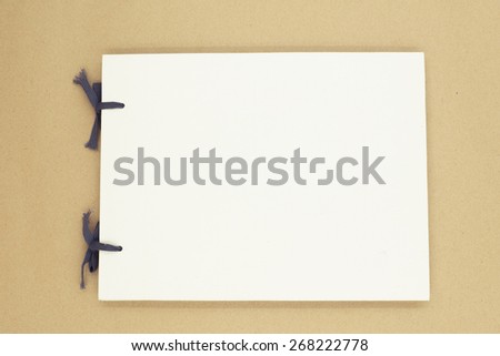 Photo blank book cover on textured wood background with retro filter effect