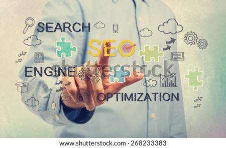 Young man in blue shirt pointing at SEO concepts